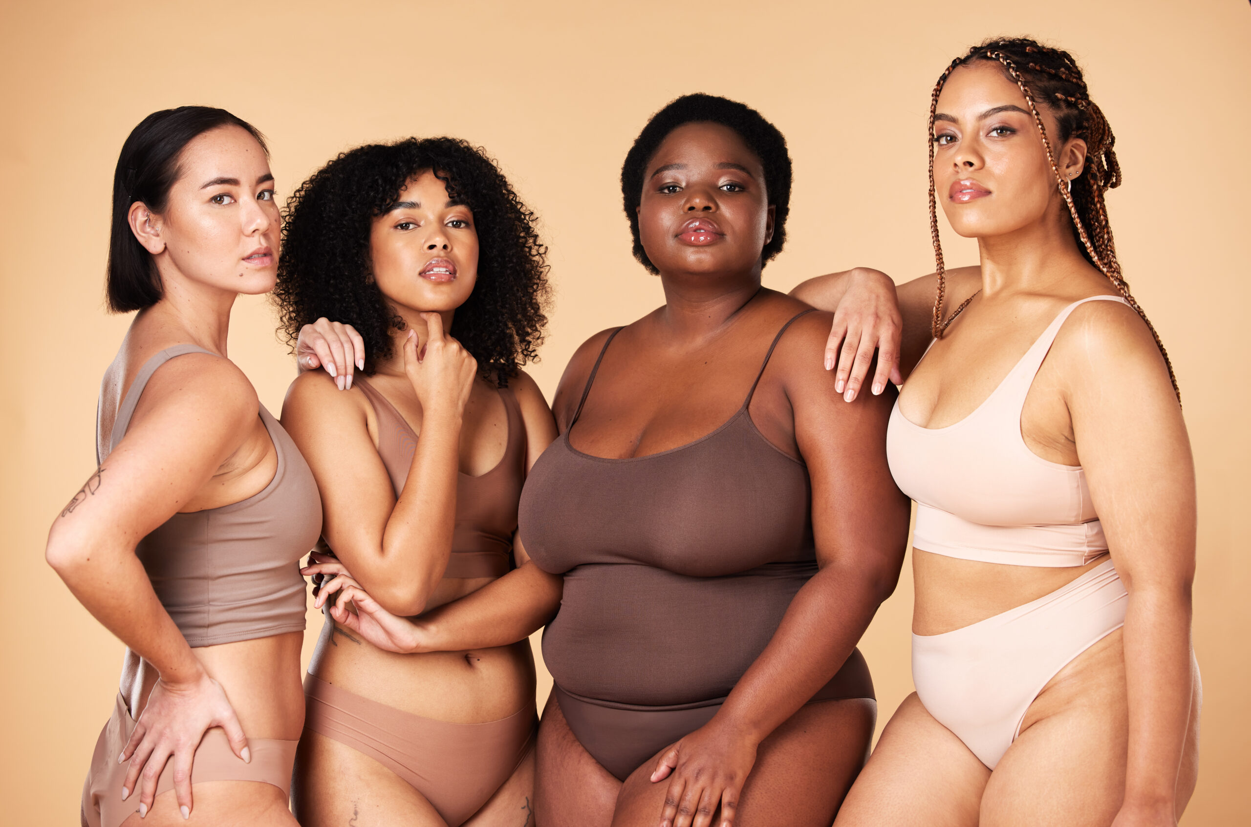 Body positive, diversity and portrait of women group together for inclusion, beauty and power. Underwear model people or friends on beige background for skincare, pride and motivation for self love